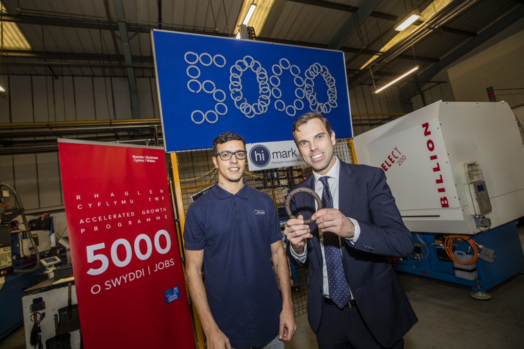 Tiago Szabo, a factory operator for Wrexham based automotive design and manufacture company Hi-Mark, which has created the 5000th job under the Business Wales Accelerated Growth Programme, with Economy Secretary Ken Skates.