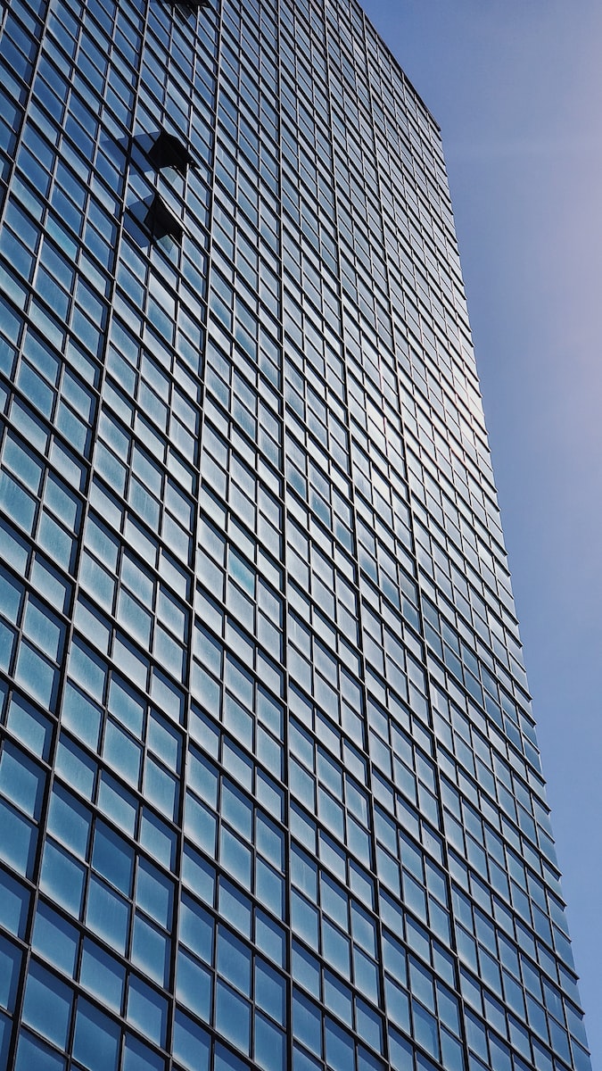 blue and white glass walled high rise building