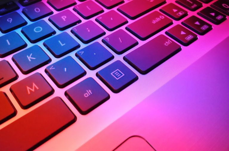 a close up of a laptop keyboard with red and blue keys